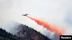 Pesawat militer AS jenis C-130 menjatuhkan air untuk memadamkan kebakaran hutan di Waldo Canyon, sebelah barat kota Colorado Springs.