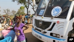 FILE - A woman from South Sudan stands in front of a UNHCR passenger bus at a refugee registration site near Bidi Bidi, Uganda, Dec. 11, 2016. The U.N. refugee agency reports that 1.6 million South Sudanese have now fled to neighboring countries.