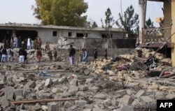 FILE - Afghan security forces inspect the site of a bomb attack in Lashkar Gah, the capital of Helmand province, March 18, 2015.