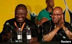 FILE: South Africa's President Jacob Zuma, right, jokes with his deputy, Cyril Ramaphosa, after Zuma's re-election in 2012.