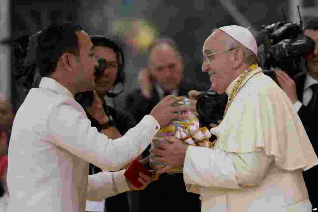 Pope Francis is presented with a jar containing messages of former street children during his meeting with the youth in Santo Tomas University in Manila, Jan. 18, 2015.