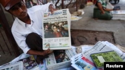 A news vendor displays local newspapers on a street in Yangon November 9, 2015. Voting unfolded smoothly in Myanmar on Sunday with no reports of violence to puncture a mood of jubilation marking the Southeast Asian nation's first free nationwide election 