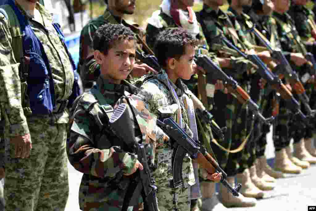 Yemeni children accompanied by their fathers hold weapons during a gathering in Sana&#39;a to show support for the Huthi Shi&#39;ite movement against the Saudi-led intervention.