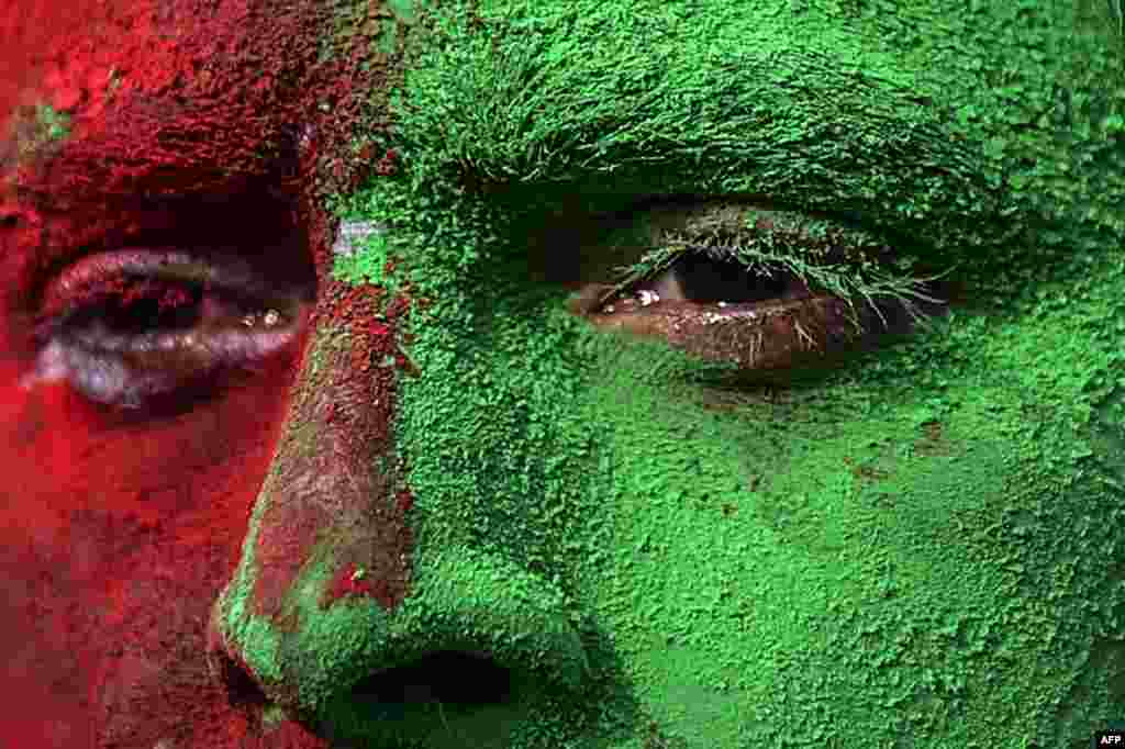 A Bangladeshi man, with his face painted in the colors of the national flag, takes part in a rally to mark the country&#39;s 44th Victory Day in Dhaka.