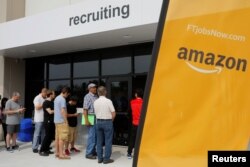 FILE - Job seekers line up to apply during "Amazon Jobs Day," a job fair being held at 10 fulfillment centers across the United States aimed at filling more than 50,000 jobs, at the Amazon.com Fulfillment Center in Fall River, Massachusetts, Aug. 2, 2017.