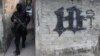 Un miembro de la Policía Nacional Civil de El Salvador camina por uno de los barrios controlados por la pandilla Barrio 18. Contra esta, junto con la Mara Salvatrucha y otras estructuras, el presidente Bukele autorizó usar la fuerza letal. 