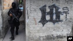 Un miembro de la Policía Nacional Civil de El Salvador camina por uno de los barrios controlados por la pandilla Barrio 18. Contra esta, junto con la Mara Salvatrucha y otras estructuras, el presidente Bukele autorizó usar la fuerza letal. 
