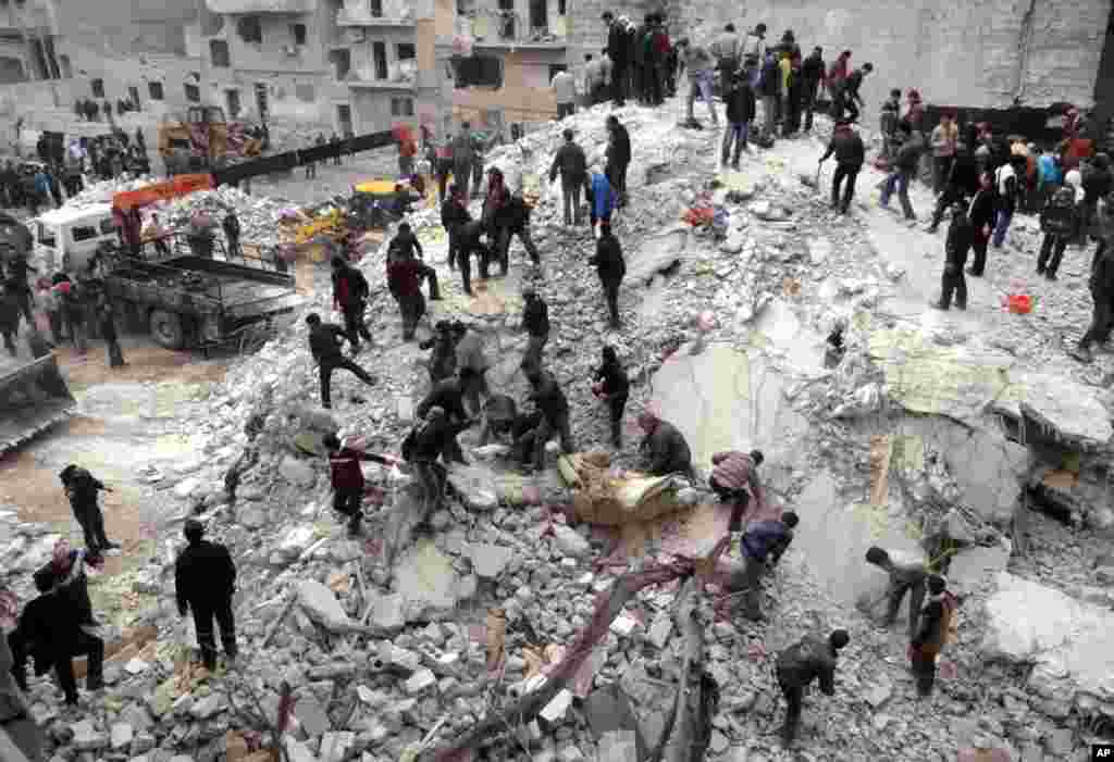 This citizen journalism image provided by Aleppo Media Center shows people searching through the debris of destroyed buildings after airstrikes hit Ansari, Aleppo, Syria, February 3, 2013.