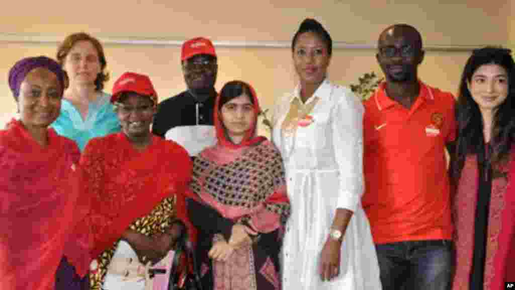 Malala Yousafzai qui a survécu à une fusillade des Talibans qui lui en voulaient pour son combat pour l&rsquo;éducation de jeunes filles, pose pour une photo avec des organisateurs de la campagne Ramenez-Nous Nos Filles à Abudja, Nigeria, dimanche le 13 juillet 2014. (AP Photo/Olamikan Gbemiga) 