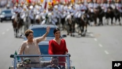 Presiden Brasil Dilma Rousseff (kiri), didampingi putrinya Paula Rousseff Araujo, melambaikan tangannya kepada publik dalam kendaraan Rolls Royce menuju gedung Kongres untuk upacara pelantikannya sebagai Presiden untuk masa jabatan kedua di Brasilia, Brazil (1/1).