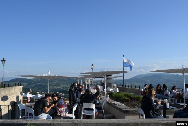 Orang-orang duduk di sebuah bar, saat Republik San Marino memulai kampanye mengundang wisatawan untuk divaksinasi dengan vaksin Sputnik V COVID-19 Rusia, 1 Juni 2021. (REUTERS)