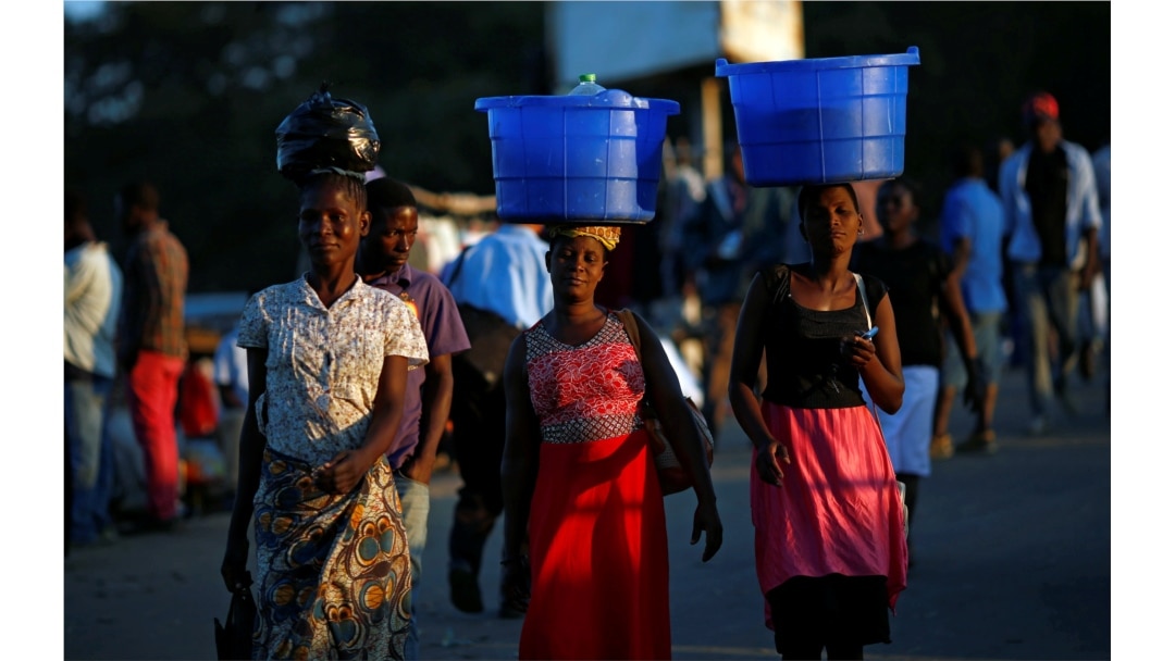 Para perempuan membawa keranjang berisi makanan di kepala mereka di sebuah pasar di Blantyre, Malawi, 10 Juli 2017. (Foto: REUTERS/Siphiwe Sibeko)