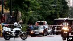 Les éléments de la sécurité et les membres des services d'urgence déployés au lieu où une explosion a blessé l'ancien Premier ministre Lucas Papademos, à Athènes, Grèce, 25 mai 2017.