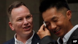 喜极而泣的香港移民官梁镇罡和他的英籍同性婚姻配偶史葛在香港终审法院外接受媒体采访。（2019年6月6日）