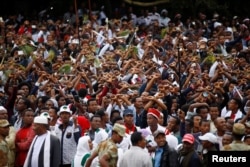 FILE - Demonstrators chant slogans while flashing the Oromo protest gesture during Irreecha, the thanksgiving festival of the Oromo people, in Bishoftu town, Oromia region, Ethiopia, Oct. 2, 2016.