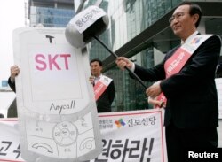 Roh Hoe-chan, pemimpin Partai Progresif Baru, berpura-pura memukul ponsel dengan palu tiruan pada rapat umum untuk menuntut pemotongan SK Telecom, di Seoul 14 September 2009. (Foto: dok).