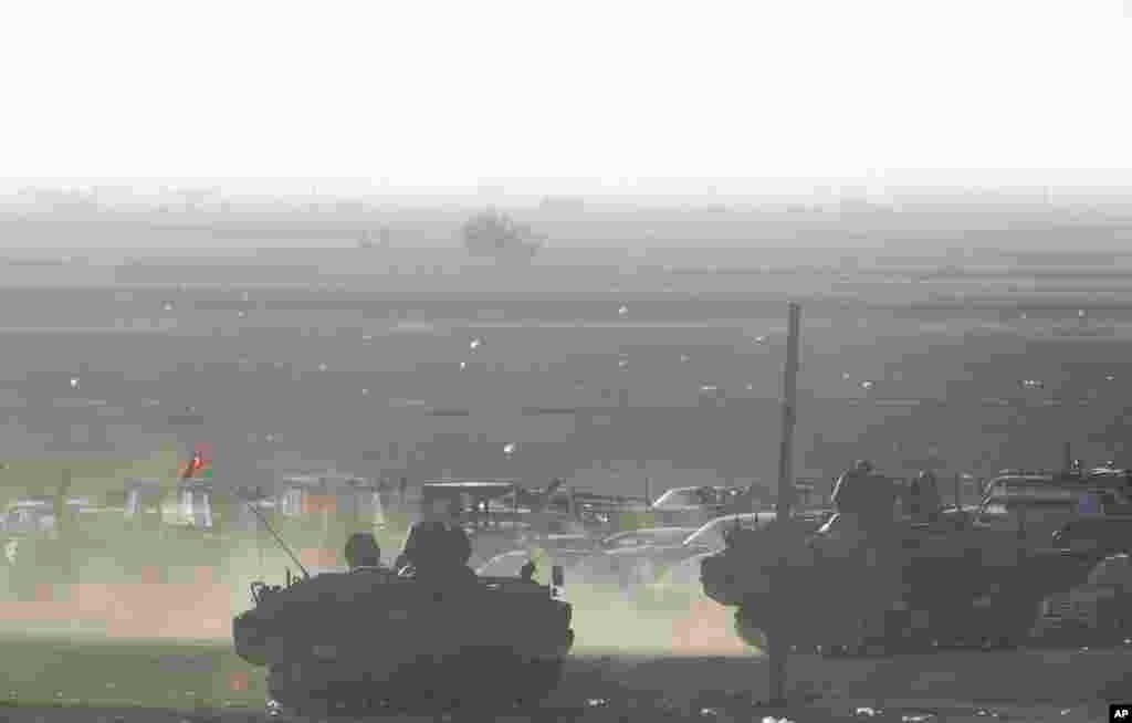 Turkish forces secure the border road in Mursitpinar, on the outskirts of Suruc, as fighting intensified in Kobani, Syria, Oct. 7, 2014.