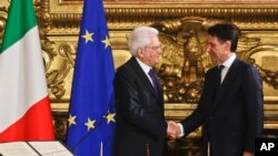 Italian President Sergio Mattarella (L) shakes hands with Premier Giuseppe Conte during the swearing-in ceremony for Italy's new government at Rome's Quirinale Presidential Palace, June 1, 2018. 