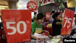 Employees prepare their clothes stall as they wait for customers at a shopping centre in Jakarta, August 6, 2012. 