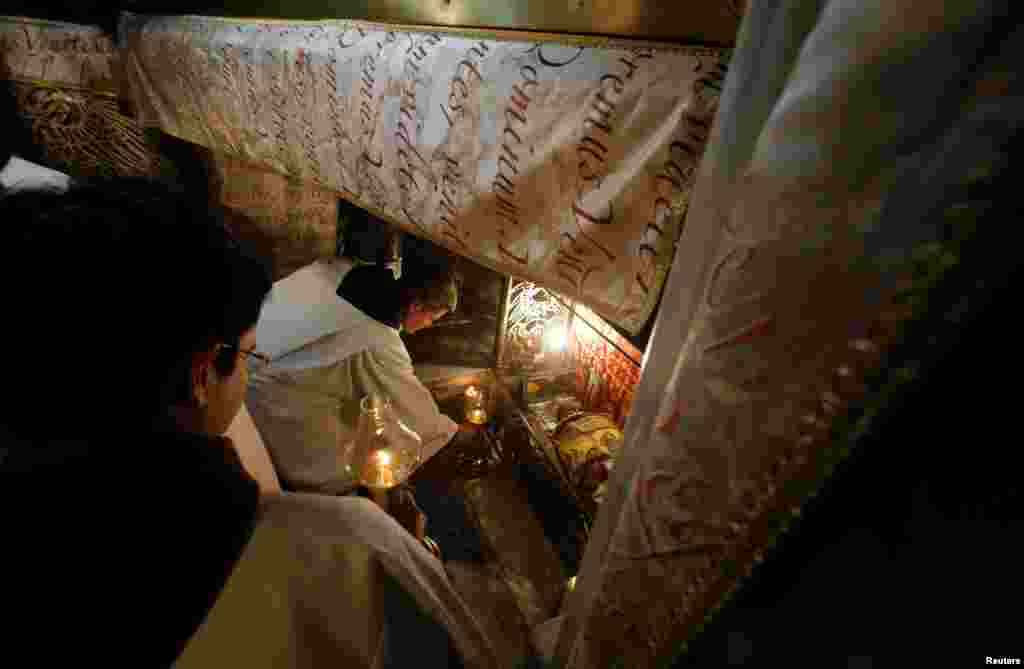 Clergymen attend a Christmas midnight mass at the Church of the Nativity in the West Bank city of Bethlehem, Dec. 25, 2017.