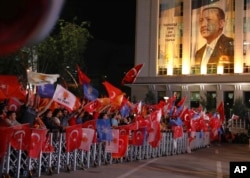 Supporters of Turkey's President and leader of ruling Justice and Development Party Recep Tayyip Erdogan celebrate outside his party's headquarters in Ankara, Turkey, late Sunday, June 24, 2018.