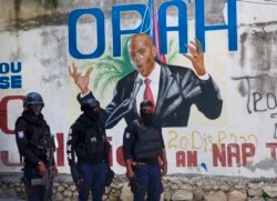 Polisi berdiri di dekat mural yang menampilkan Presiden Haiti Jovenel Moise, di dekat kediaman pemimpin tempat dia dibunuh oleh orang-orang bersenjata pada dini hari di Port-au-Prince, Haiti, Rabu, 7 Juli 2021. (Foto: AP/Joseph Odelyn)