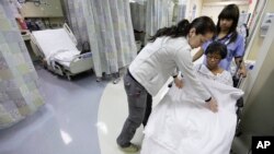 FILE - Nurses at a US hospital are seen tending to a patient.