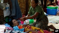 A family member takes care of a HIV patient at HIV/AIDS care center founded by Phyu Phyu Thin, a parliament member of Burma's Opposition Leader Aung San Suu Kyi's NLD Party, in outskirts of Rangoon, Mar. 1, 2014.