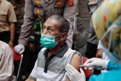 Inan Rustandi, 72 tahun, warga Desa Sindanglaya, bereaksi saat menerima dosis pertama vaksin Sinovac Biotech, Jawa Barat, 15 Juni 2021. (Foto: REUTERS/Willy Kurniawan)