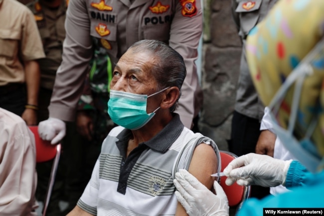 Inan Rustandi, 72 tahun, warga Desa Sindanglaya, bereaksi saat menerima dosis pertama vaksin Sinovac Biotech, Jawa Barat, 15 Juni 2021. (Foto: REUTERS/Willy Kurniawan)