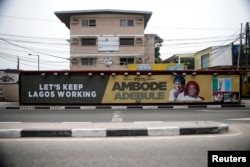 A campaign banner in support of the opposition All Progressives Congress (APC) governorship candidate Akinwunmi Ambode and his running mate, Oluranti Adebule, is seen along a road in Ikoyi district in Lagos, Feb. 13, 2015.