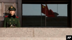 FILE - A paramilitary policeman stands guard at an entrance of China's Supreme Court in Beijing.