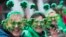 Sharon Keely, left, of Dublin, watches as participants march up Fifth Avenue during the St. Patrick's Day Parade, March 16, 2019, in New York. 