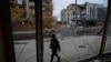 FILE - A photographer walks past buildings damaged by a Russian military strike, in the town of Pokrovsk in Donetsk region, Ukraine, Nov. 4, 2024. 