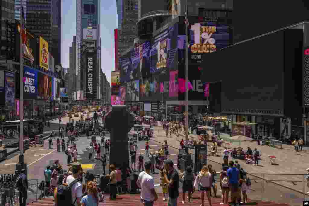 Personas caminan frente a pantallas apagadas en Times Square, el viernes 19 de julio de 2024, en Nueva York, debido al apagón tecnológico global.