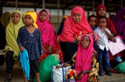 FILE - Somali refugee families wait to be flown to Kismayo in Somalia under a voluntary repatriation program, at the airstrip of Dadaab refugee camp, in northern Kenya, Dec. 19, 2017.