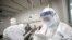 A medical worker in protective suit checks a patient's records at Jinyintan hospital in Wuhan, the epicenter of the novel coronavirus outbreak, in Hubei province, China, Feb. 13, 2020.