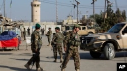 Afghanistan's National Army soldiers stand guard, blocking the main road to the Bagram Airfield's main gate in Bagram, north of Kabul, Afghanistan, Nov. 12, 2016.