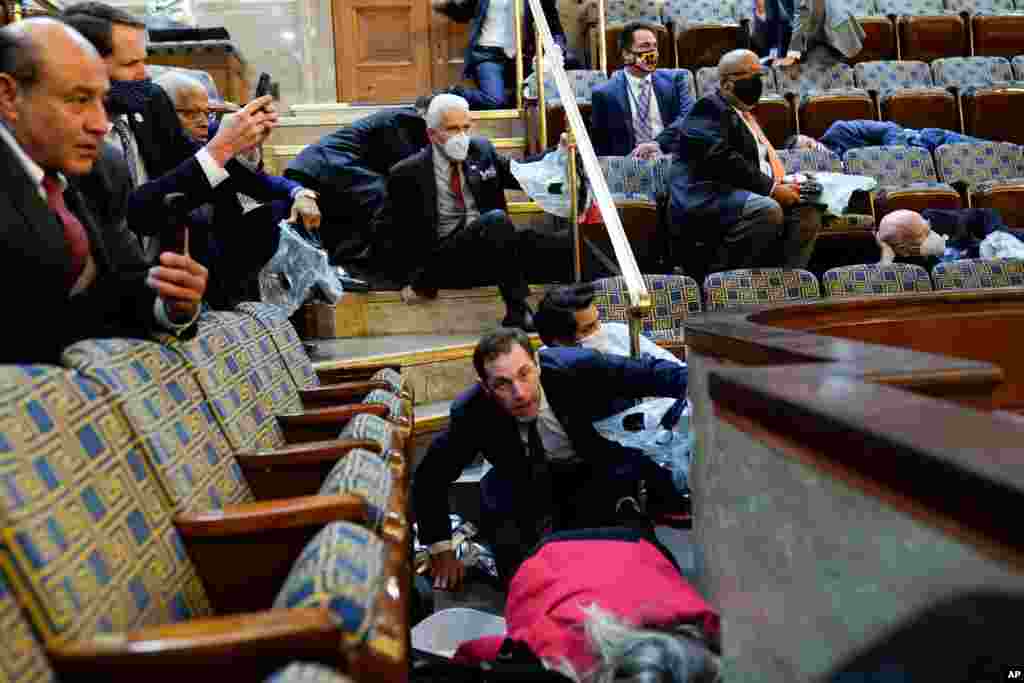 People shelter in the House gallery as protesters try to break into the House Chamber at the U.S. Capitol in Washington.