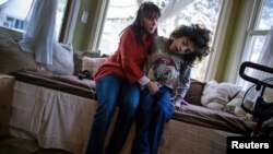 Missy Miller sits with her epileptic son, Oliver (R), in their home near Atlantic Beach, New York, Jan. 7, 2014.