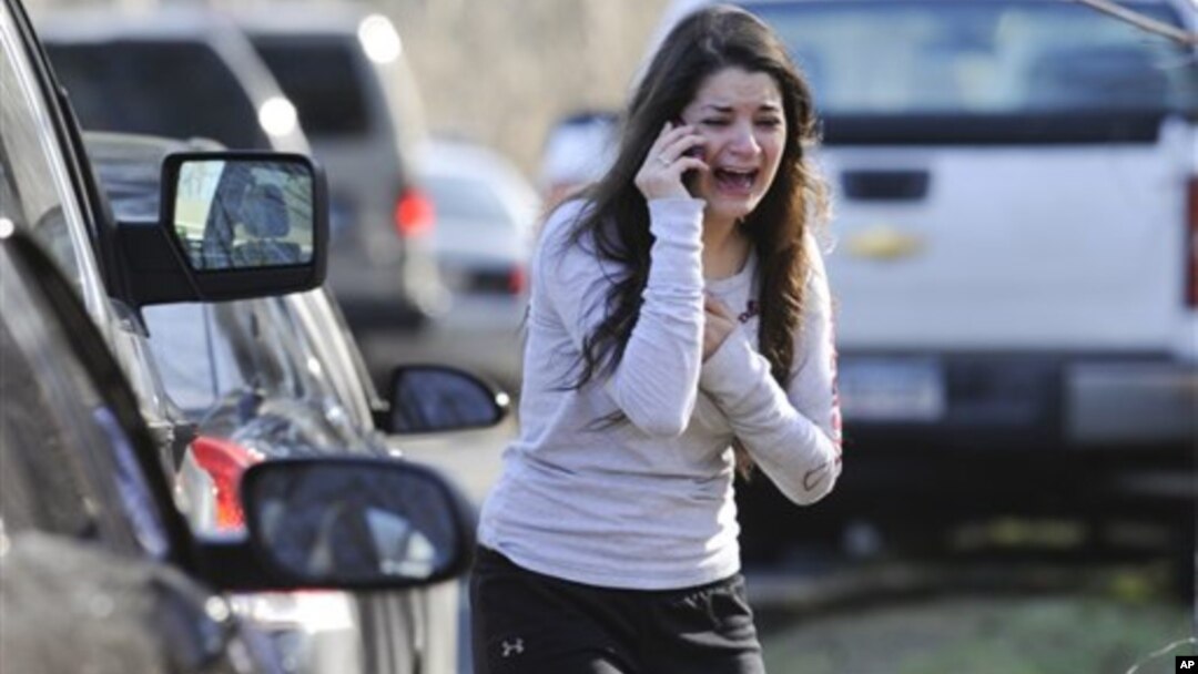 Mulher desesperada aguarda notícias sobre a sua irmã, uma professora na Escola Primária de Sandy Hook, em Newtown, no estado de Connecticut.