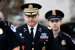 FILE - Army Lt. Col. Alexander Vindman, center, arrives on Capitol Hill in Washington to testify as part of the U.S. House impeachment inquiry into President Donald Trump, Oct. 29, 2019.