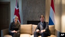 La Première ministre britannique Theresa May, à gauche, et le Premier ministre néerlandais, Mark Rutte, posent devant les photographes au début d'une réunion à La Haye, aux Pays-Bas, le mardi 11 décembre 2018. (AP Photo / Peter Dejong, Pool)