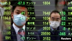 Passersby wearing protective face masks following an outbreak of the coronavirus disease (COVID-19)