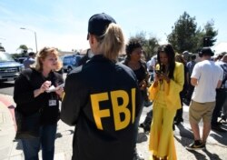 An FBI agent gives out information to members of the media outside of the Chabad of Poway Synagogue, April 27, 2019, in Poway, Calif. Several people were injured in a shooting at the synagogue.