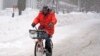 Terrence Yarbrough, de Erie, Pensilvania, viaja en su bici por las calles cubiertas de nieve, en el centro de Erie, el 2 de diciembre de 2024. (AP Foto/Gene J. Puskar).