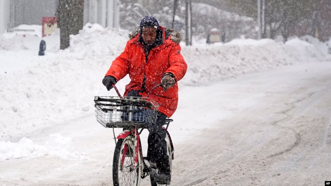 Terrence Yarbrough, de Erie, Pensilvania, viaja en su bici por las calles cubiertas de nieve, en el centro de Erie, el 2 de diciembre de 2024. (AP Foto/Gene J. Puskar).