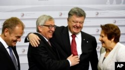 European Commission President Jean-Claude Juncker, center left, greets Ukrainian President Petro Poroshenko, center right, and Latvia Prime Minister Laimdota Straujuma, right, during arrivals at the Eastern Partnership summit in Riga, Latvia, May 22, 2015. 