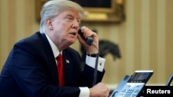 FILE - U.S. President Donald Trump speaks by phone in the Oval Office at the White House in Washington, Jan. 29, 2017.