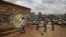 FILE - Children walk past graffiti depicting a representation of the coronavirus and warning people to sanitize to prevent its spread, in the Mathare slum of Nairobi, Kenya, April 22, 2020.
